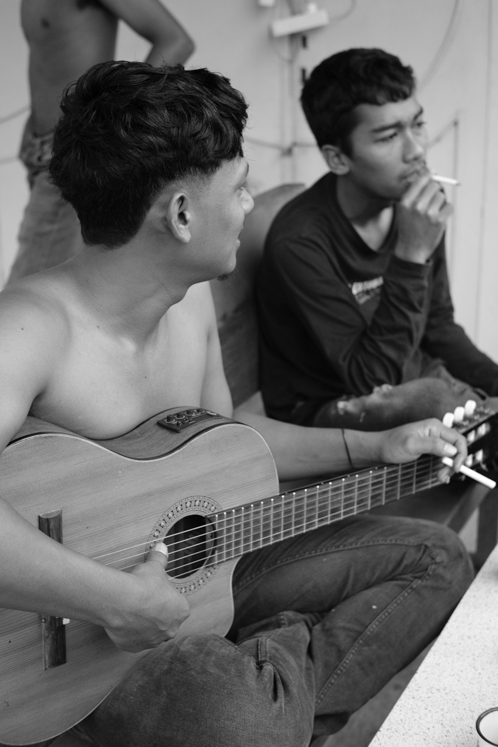 a man sitting on a couch holding a guitar