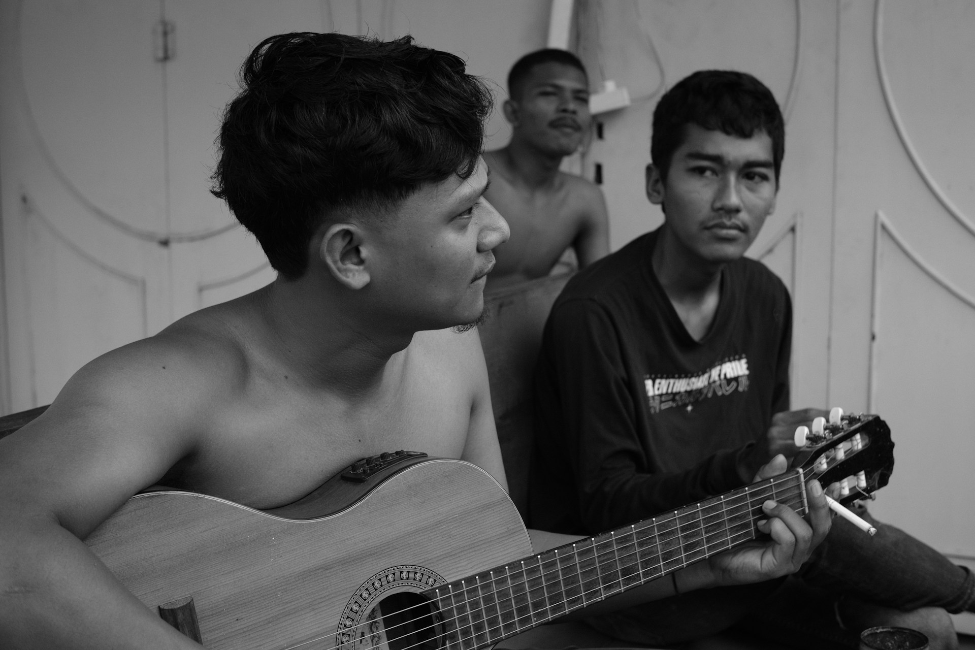 The band members Juan Carlos, Marcel, and Edwin playing their instruments together in a cozy studio setting.