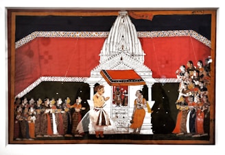 A detailed Indian painting showcases a traditional scene with a large white temple structure in the center. The temple is adorned with intricate designs and has a vivid red backdrop. In front of the temple, two figures are prominently positioned, one of whom appears to be in conversation with the other. To the left and right, groups of people are attentively gathered, wearing colorful traditional attire, indicating a ceremonial or religious gathering.