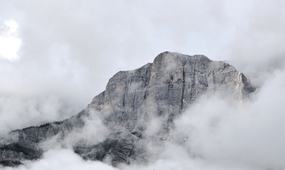 a mountain covered in fog and clouds on a cloudy day