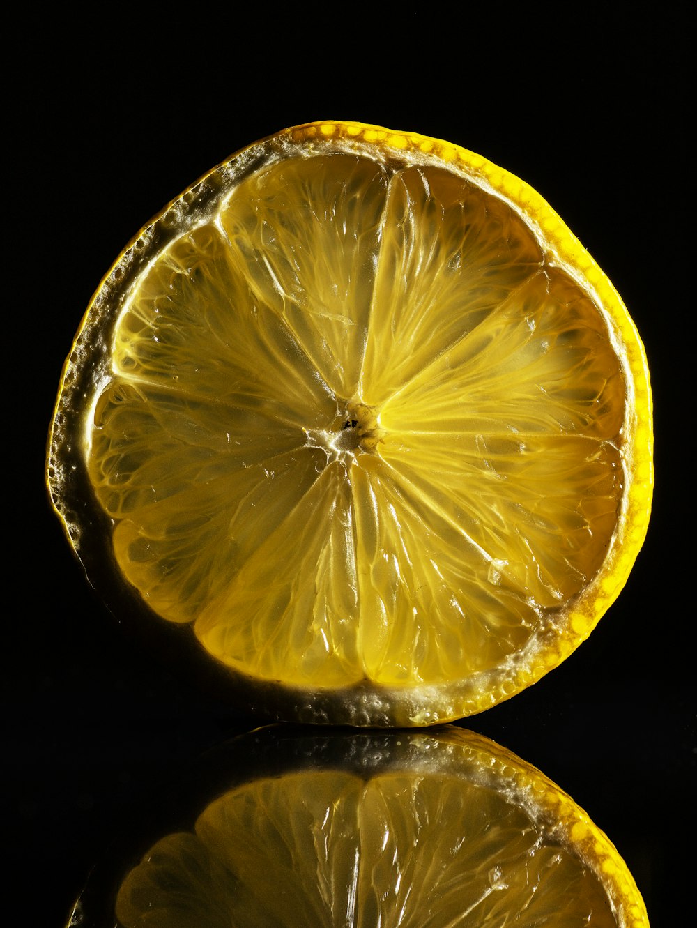 a close up of a sliced lemon on a black background