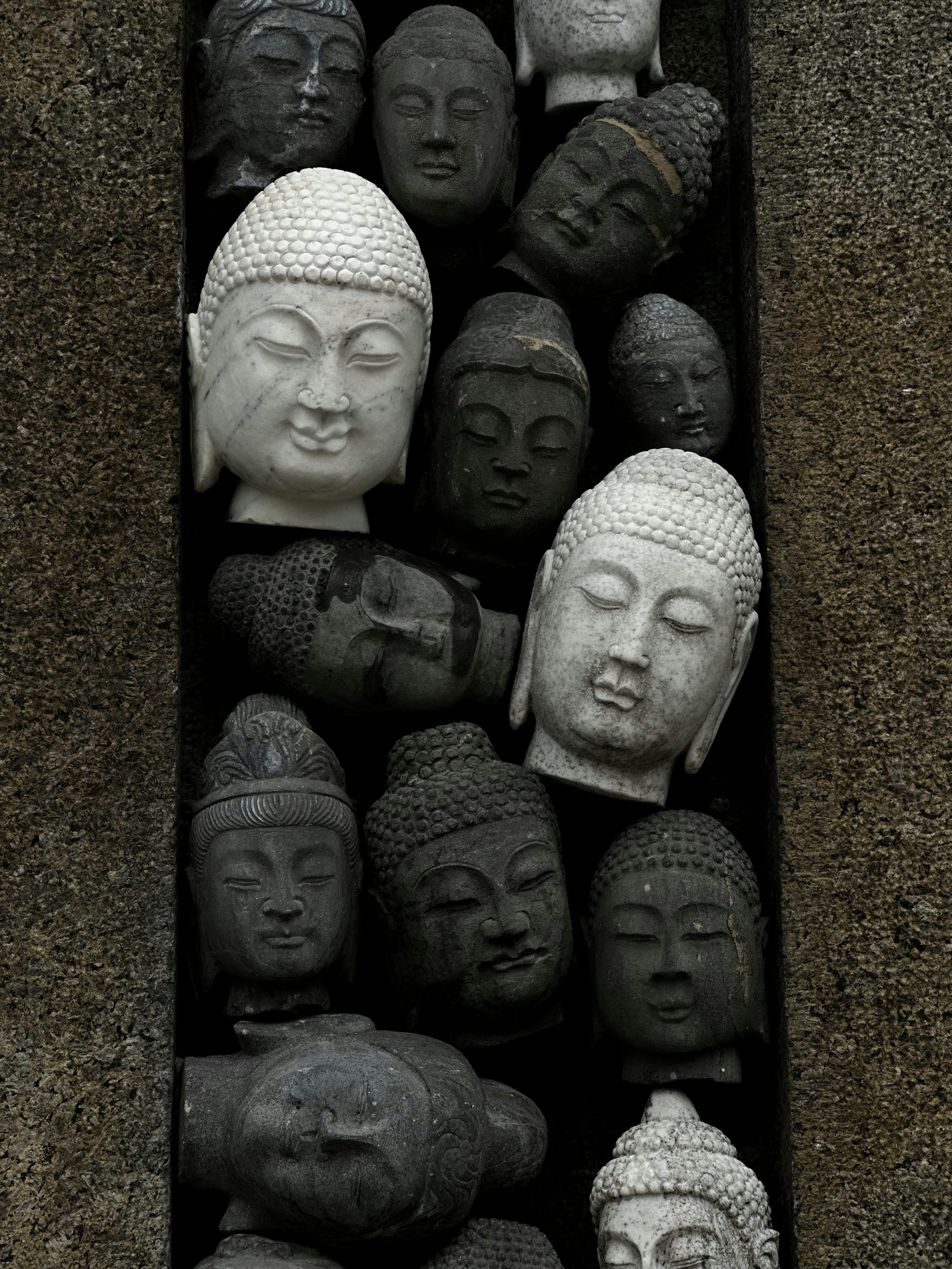 a bunch of buddha heads in a box