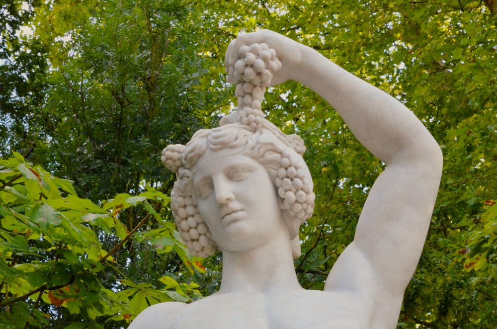 a statue of a woman holding a bunch of grapes
