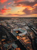 Aerial view of Cancha Vedia stadium glowing under golden lights at dusk
