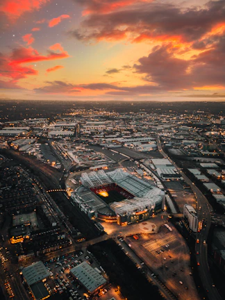 Aerial view of Cancha Vedia stadium glowing under golden lights at dusk