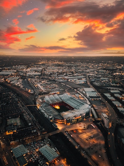 High-resolution photo of a stadium monitored by drones and security cameras at dusk.