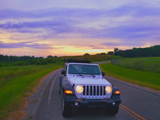 A vibrant jeep tour crossing lush green hills in Magelang during sunset.