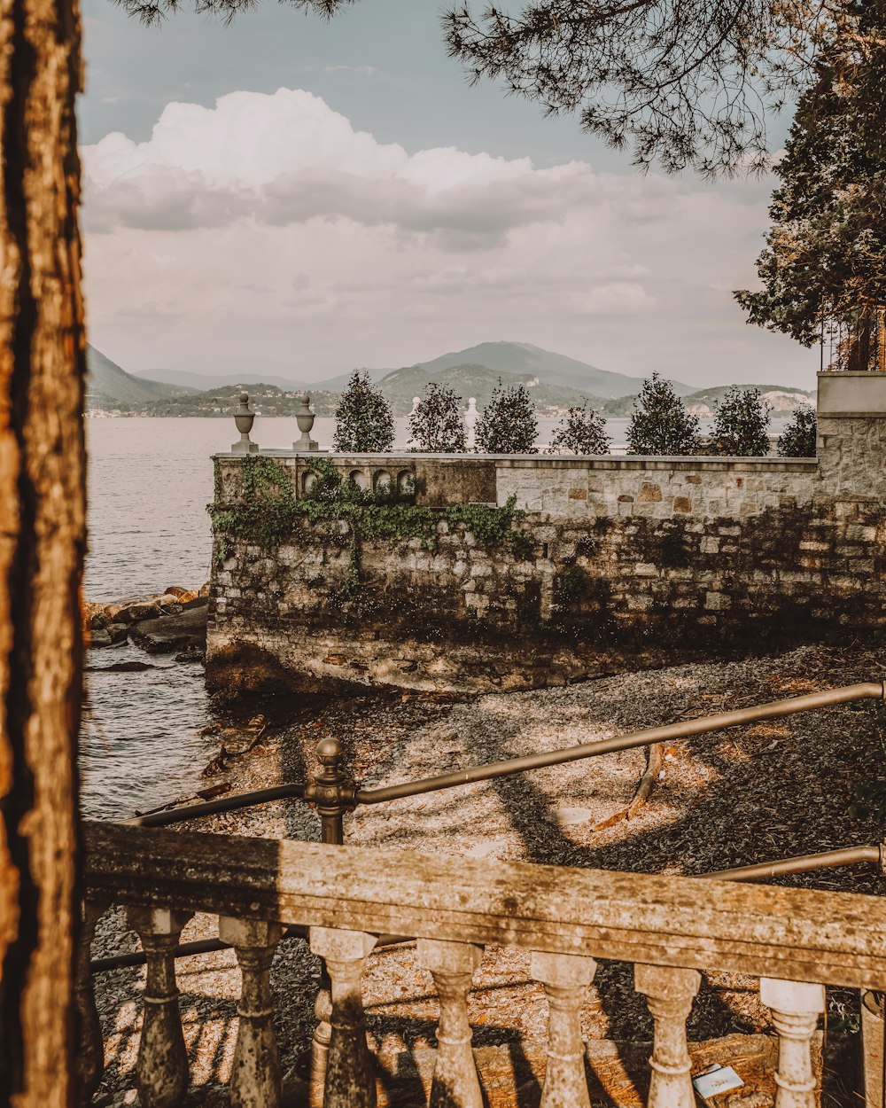 a stone wall next to a body of water