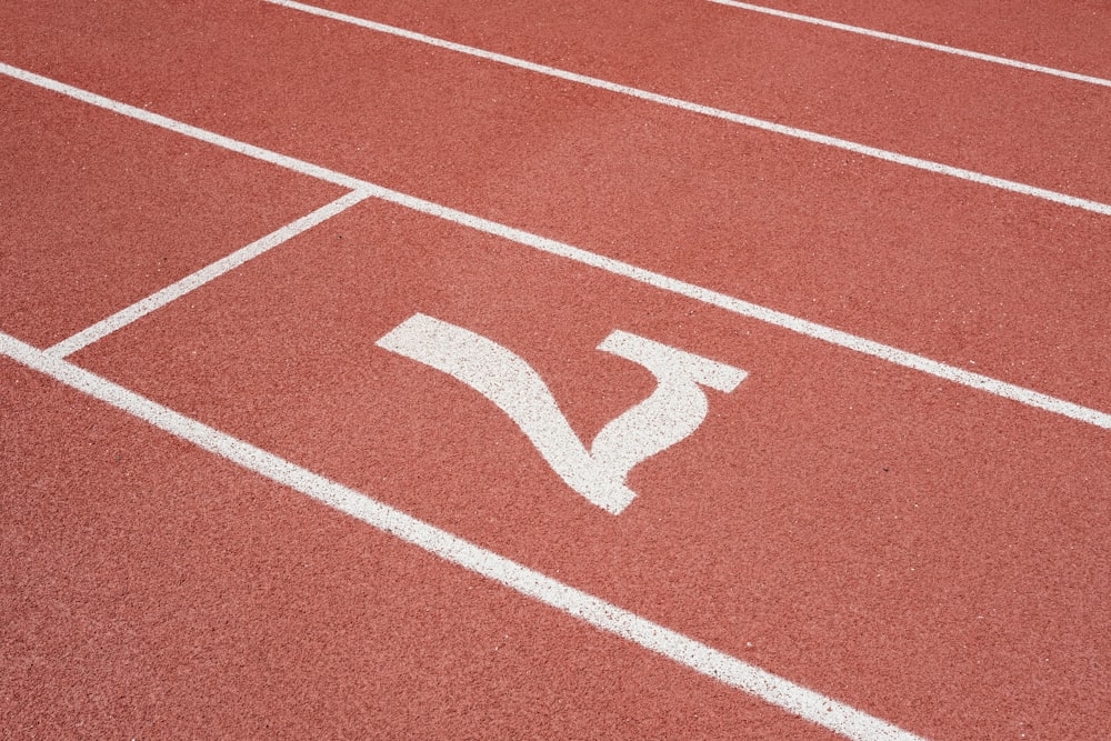 una pista de atletismo roja con una línea blanca