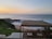 A cozy outdoor terrace with a stunning sunset view over the ocean, perfect for relaxation.