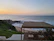 A cozy terrace overlooking the serene blue sea at sunset.