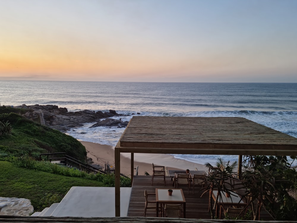 a table and chairs on a deck overlooking the ocean