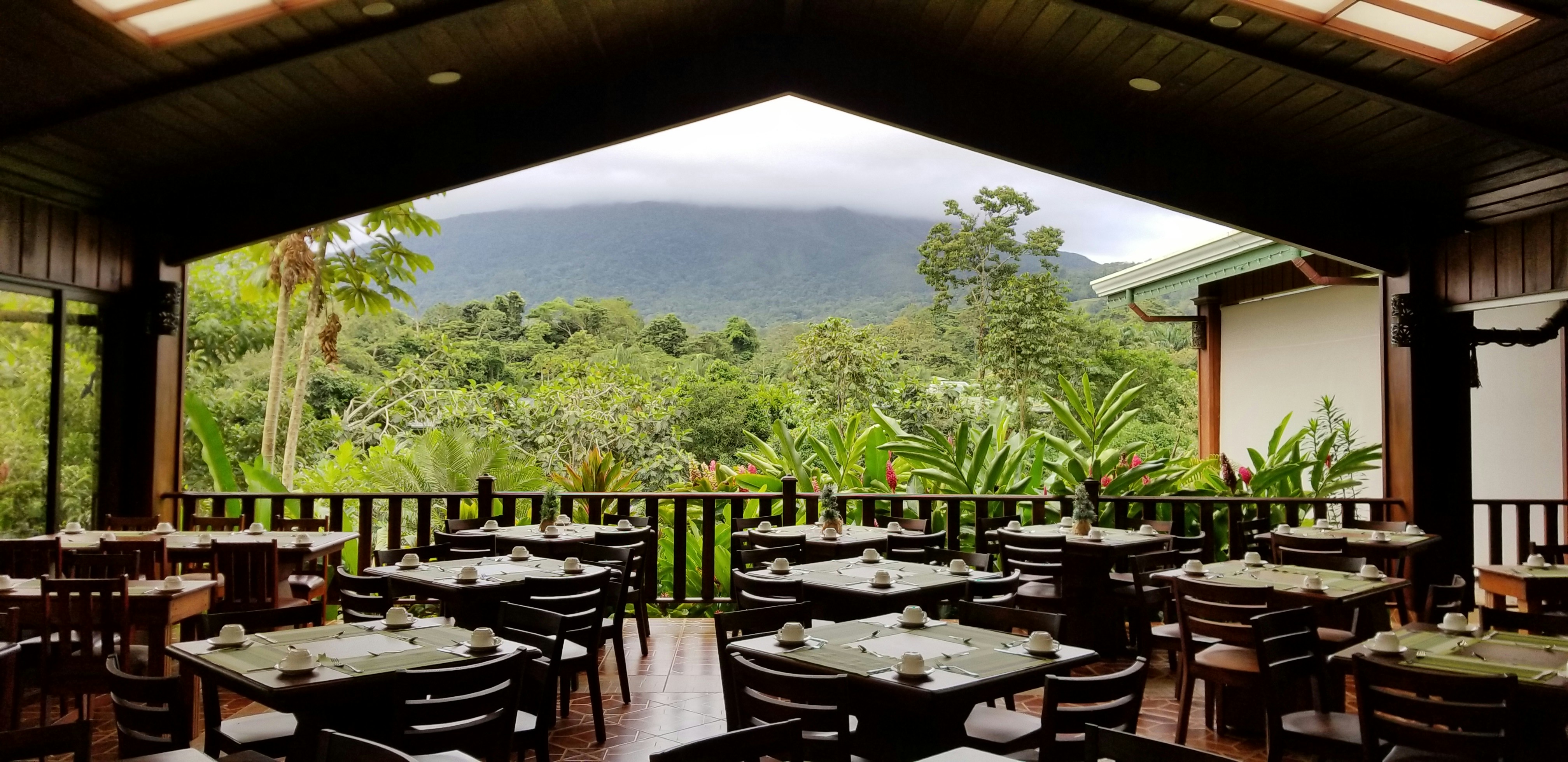 Farm-to-table restaurant with panoramic hillside views, elegant table settings and tropical decor