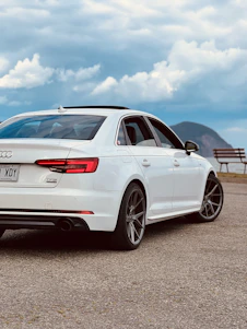A Panada Auto Transport carrier carefully loading a sedan against a scenic Canadian highway backdrop.
