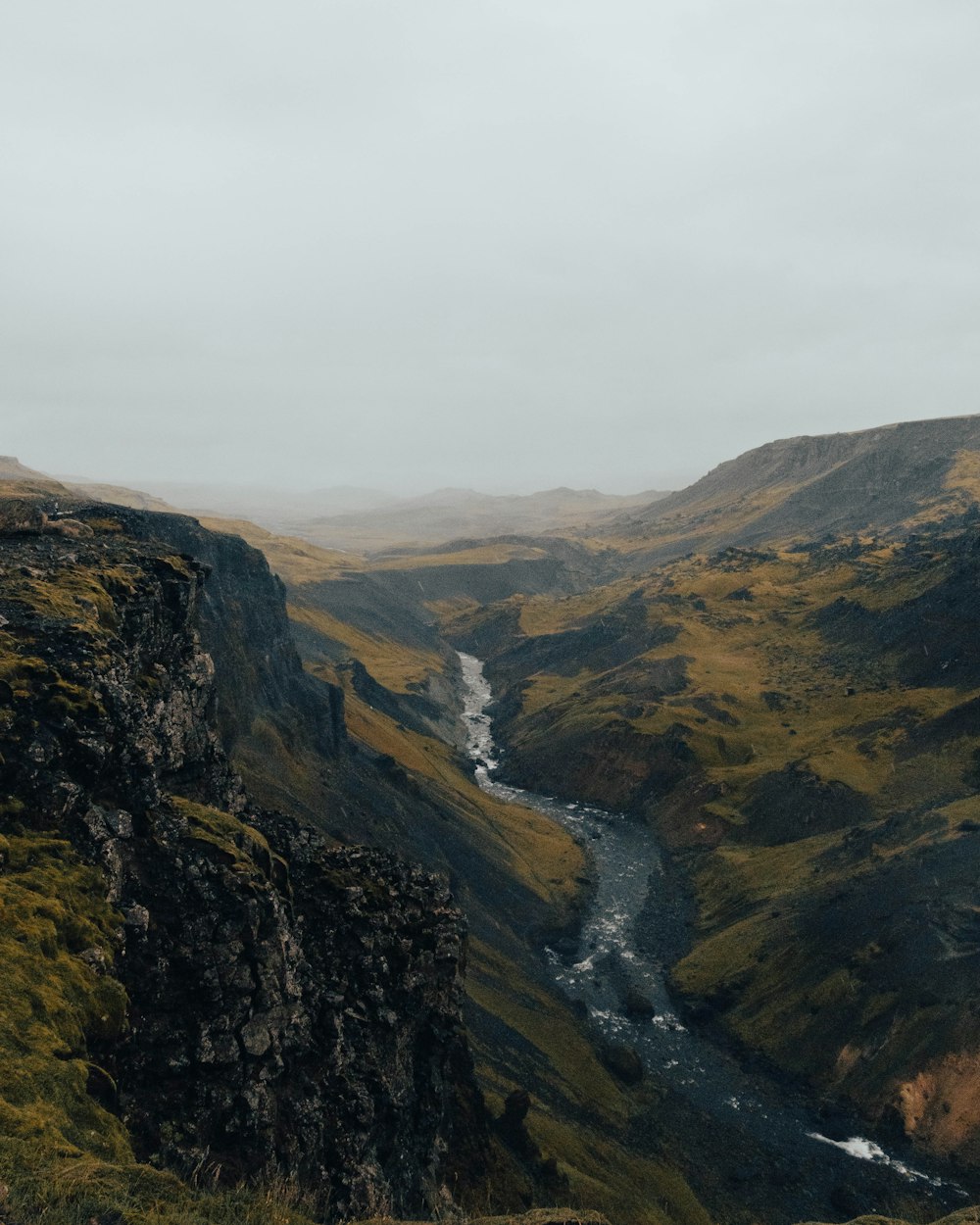 a river running through a valley surrounded by mountains