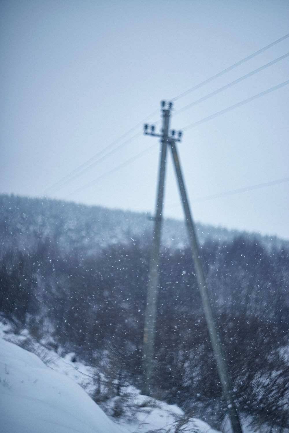 a snow covered hill with power lines in the background