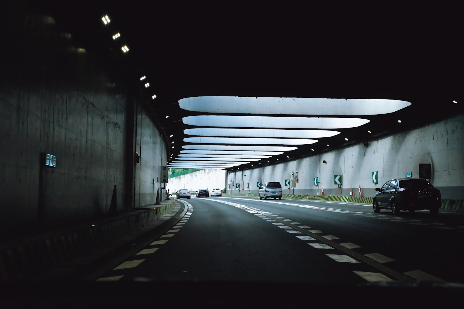 Samochody poruszające się przez oświetlony tunel drogowy
