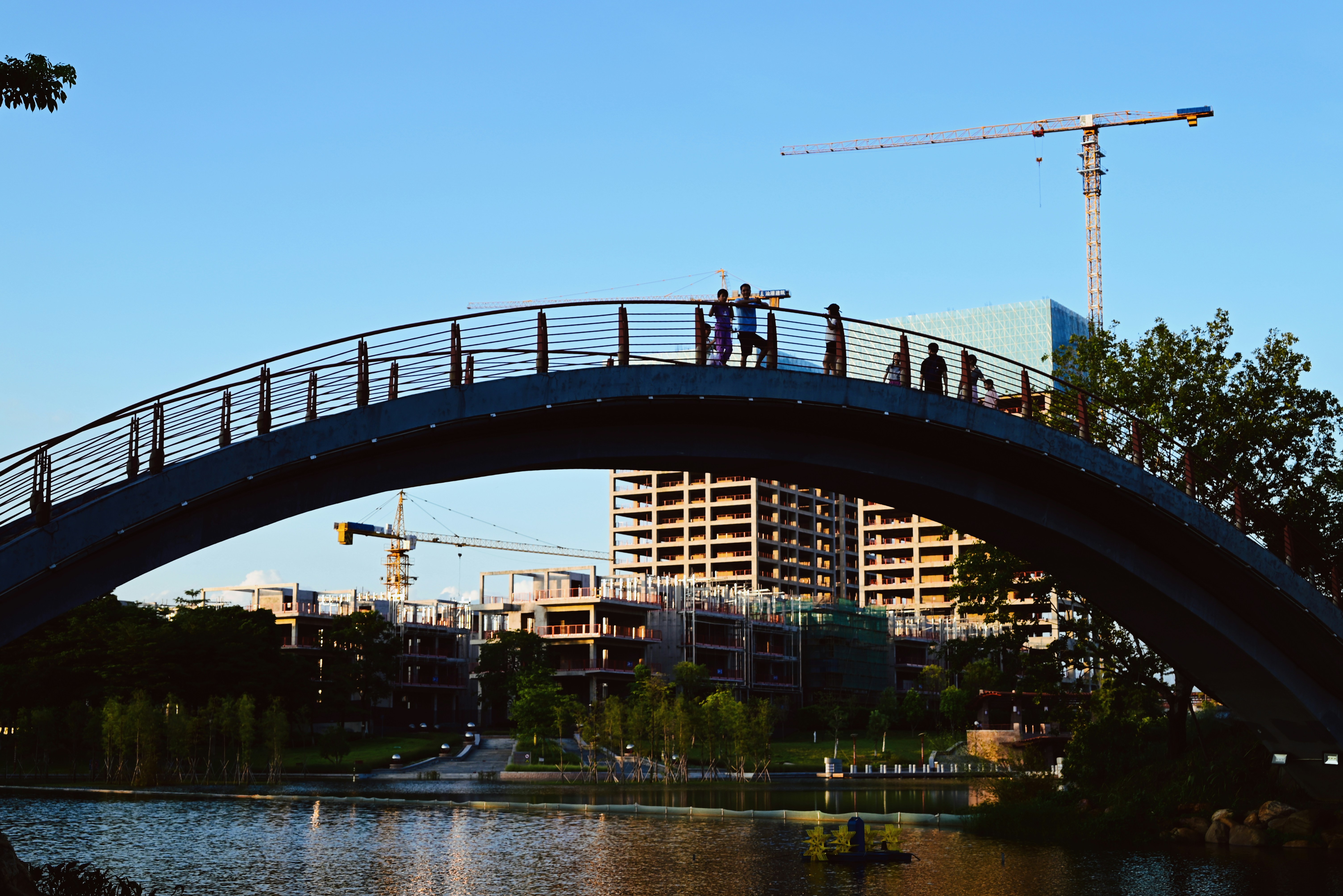 a group of people standing on a bridge over a body of water