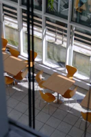 Set of vertical wooden tables arranged by a sunlit window.