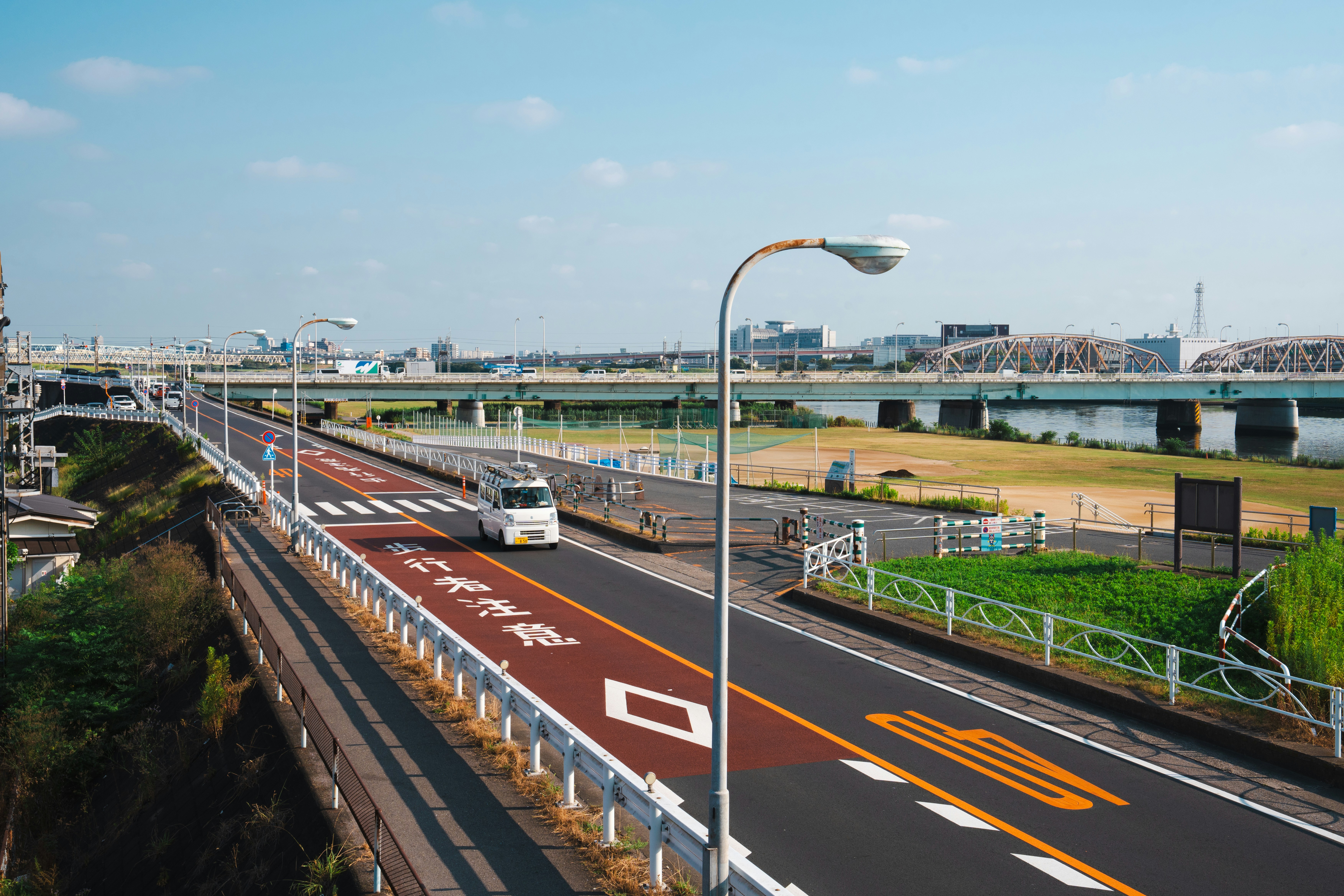 a bus driving down a street next to a bridge