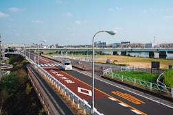 a bus driving down a street next to a bridge