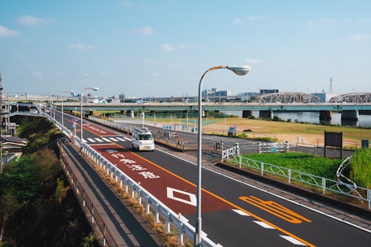 a bus driving down a street next to a bridge