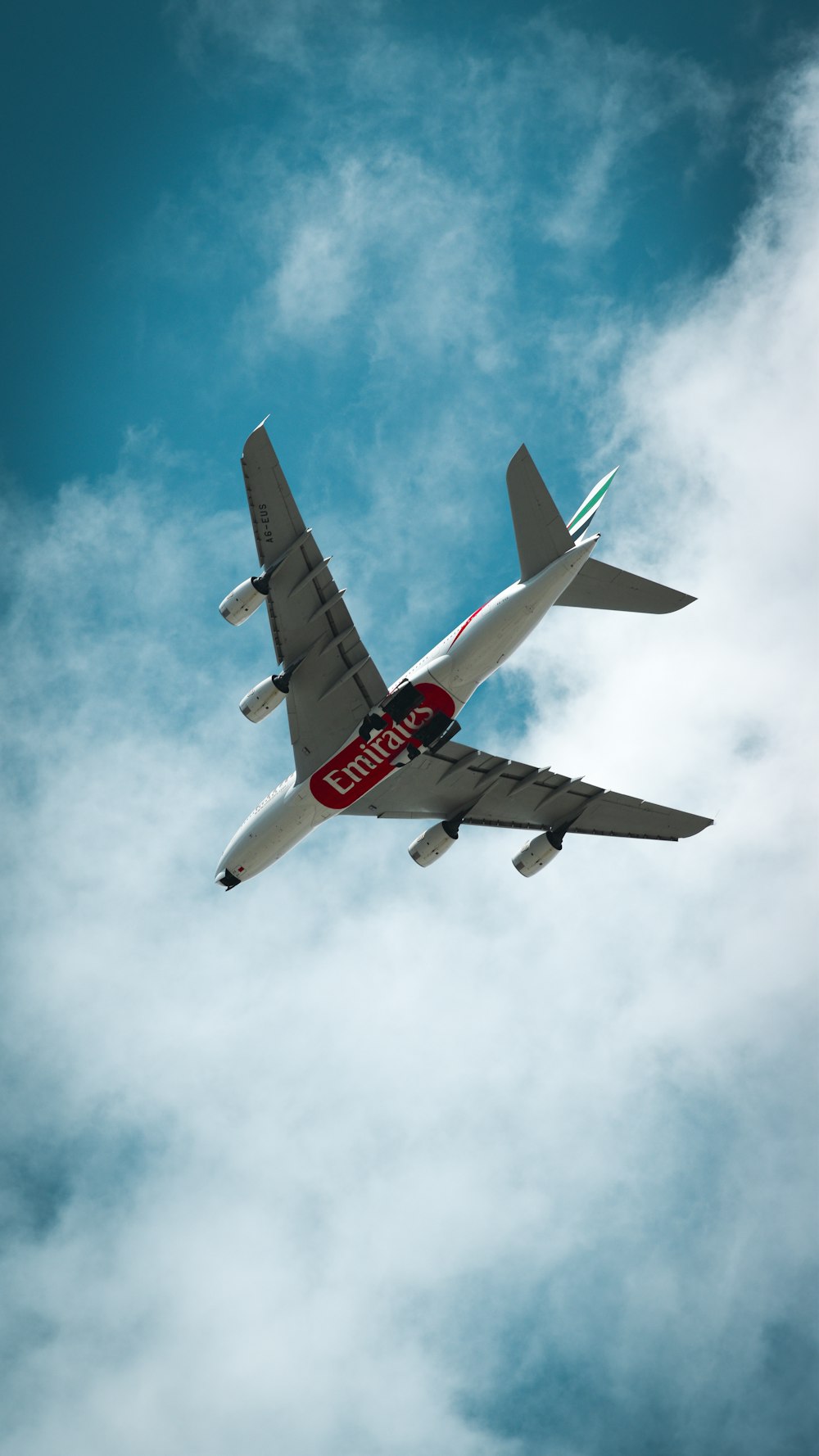 a large jetliner flying through a cloudy blue sky