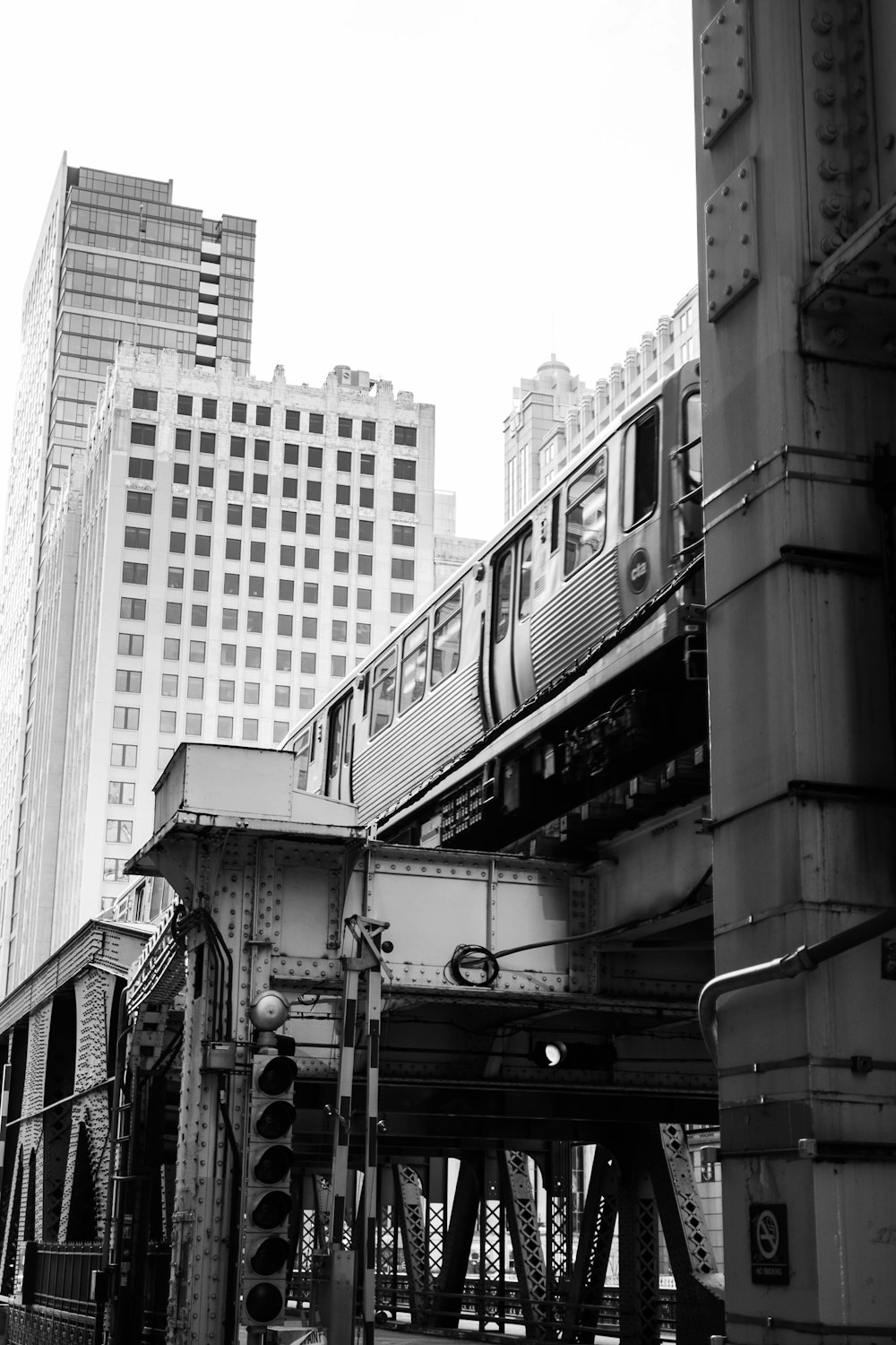 a black and white photo of a train going over a bridge