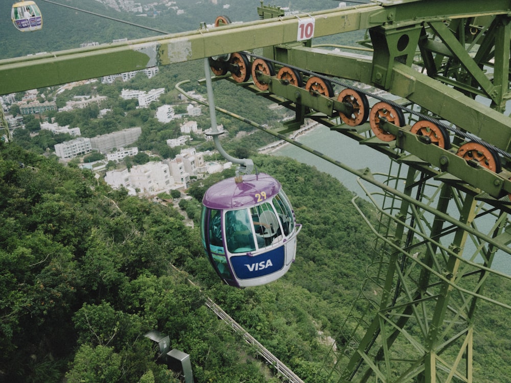 a cable car going over a lush green hillside