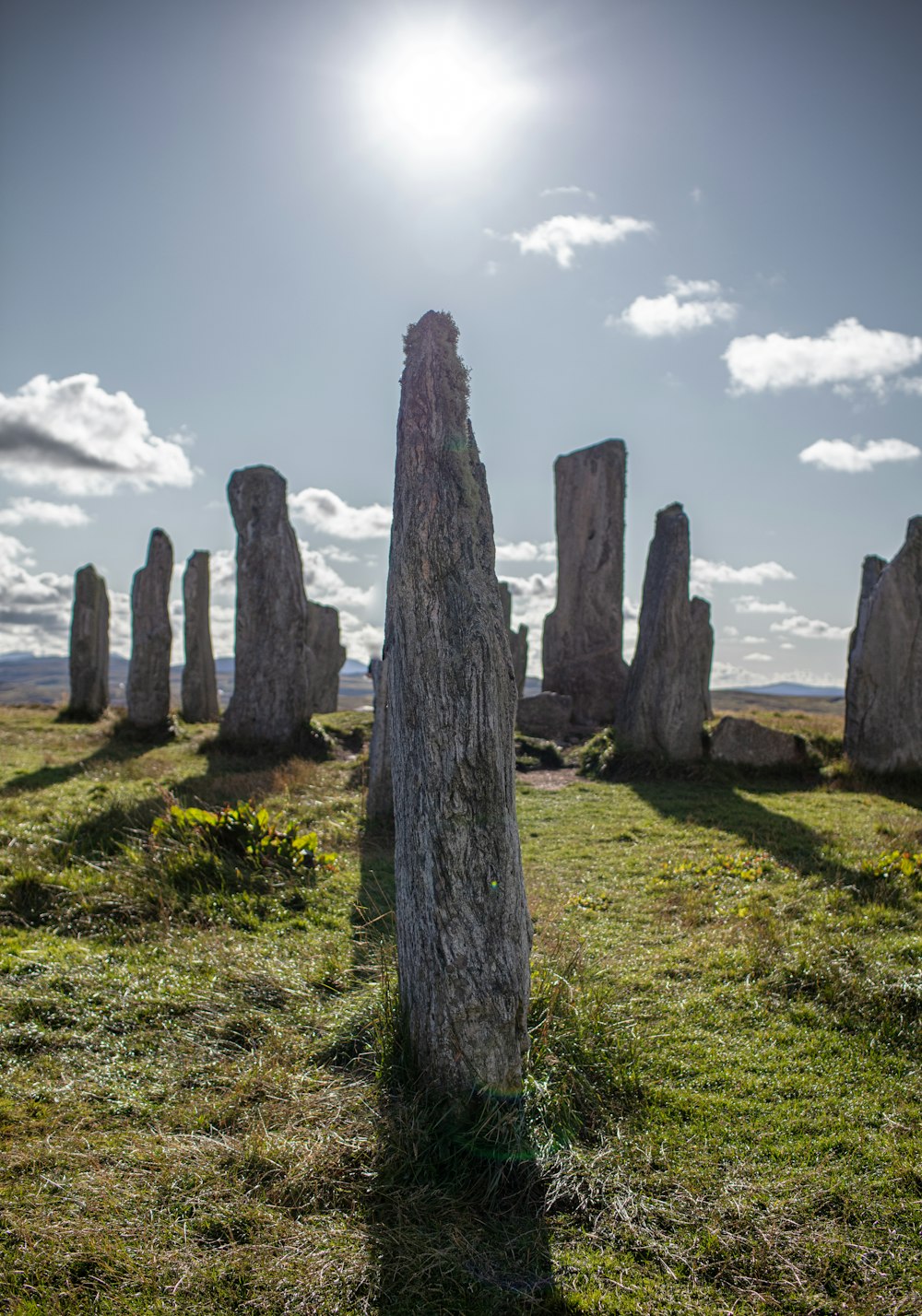 a group of stonehenge standing in a grassy field