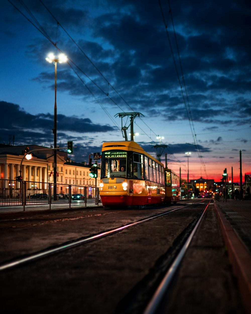 a yellow and red train traveling down train tracks