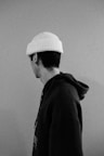 a black and white photo of a man wearing a hat