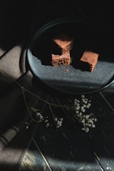 Artistic shot of a decadent dessert served on rustic oak wood, with soft shadows.