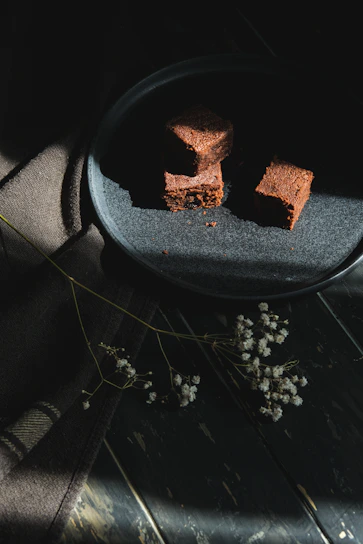 A beautifully arranged platter featuring matcha brownies alongside classic chocolate brownies, styled with soft natural light.