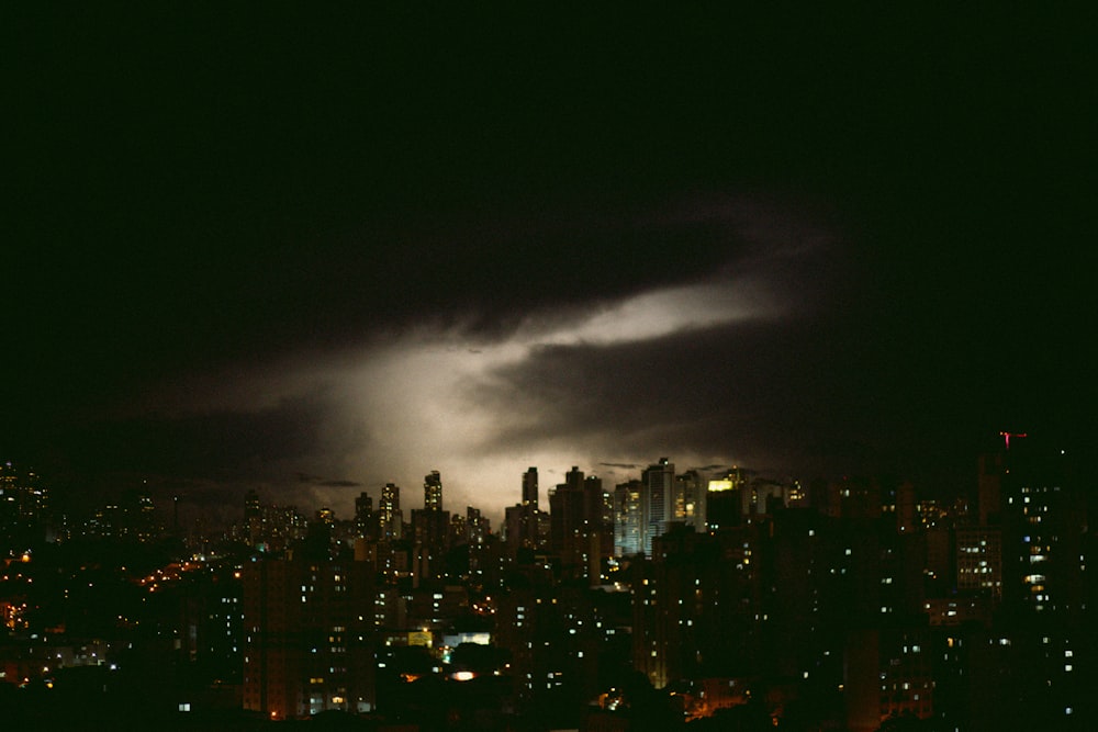 a city skyline at night with a dark sky
