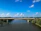 Finished concrete bridge spanning a river with clear blue sky in the background.