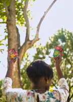 Smiling customer holding a true north nutrition package outdoors with sunlight filtering through trees.