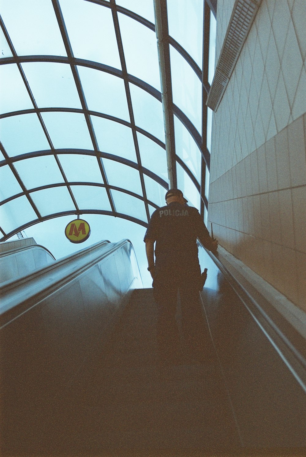 a man walking down an escalator in a building