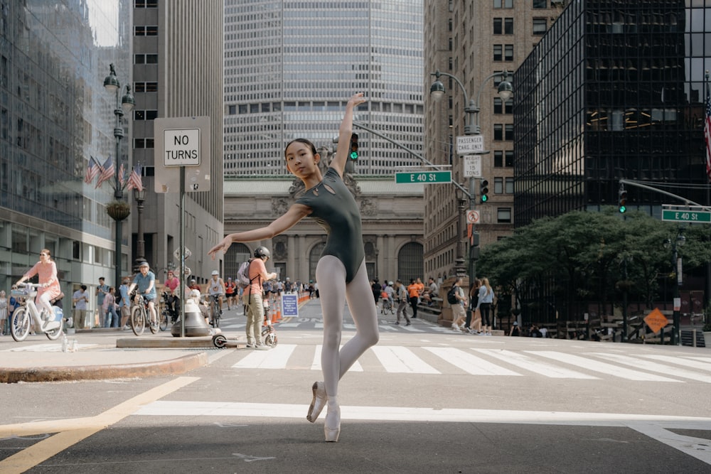 a woman in a leotard is dancing in the street