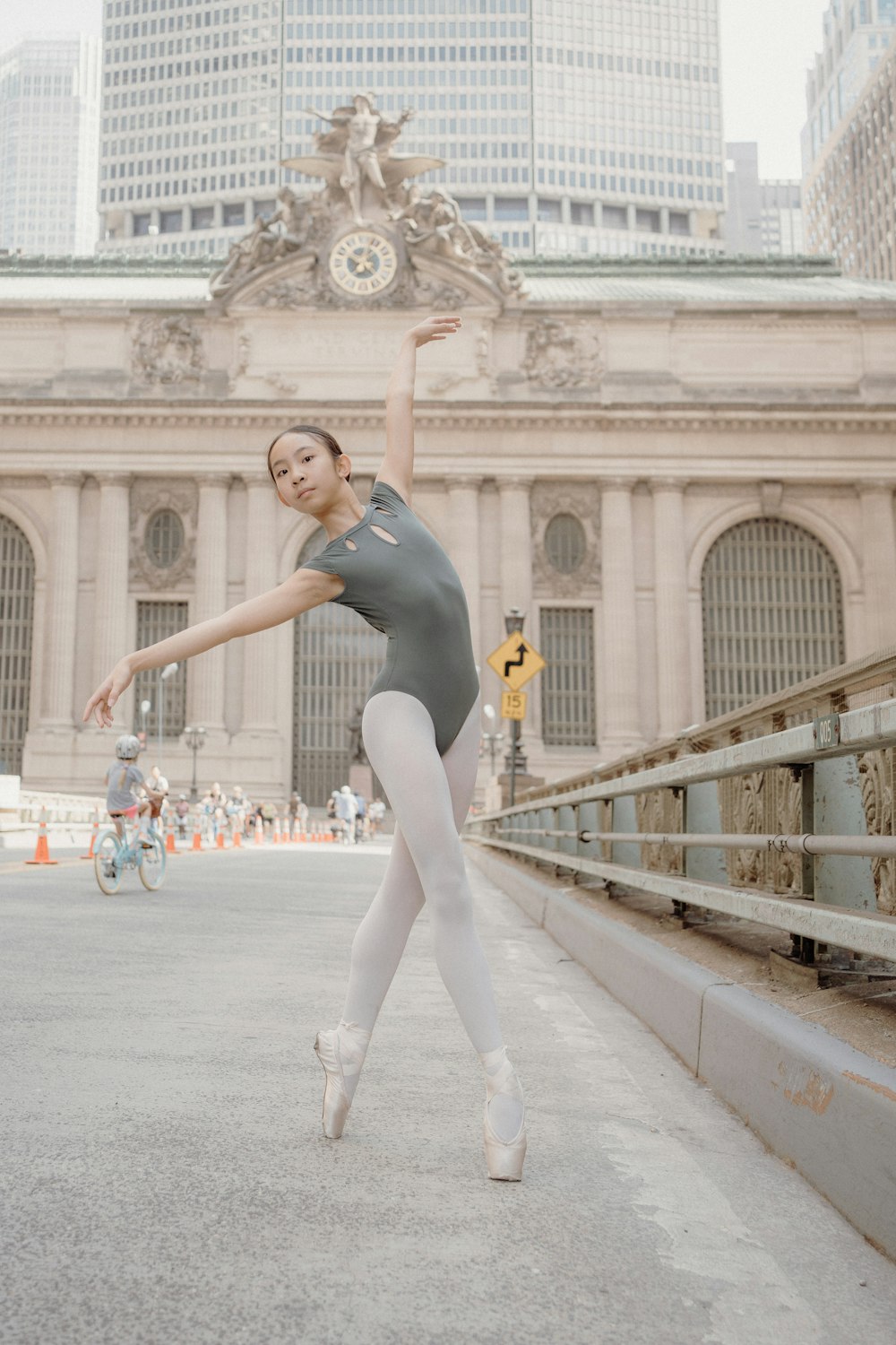 a ballerina in a gray leotard and white tights