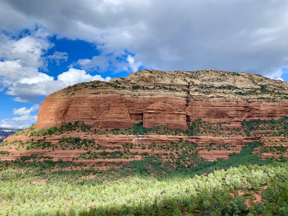 a large red rock formation with a sky background