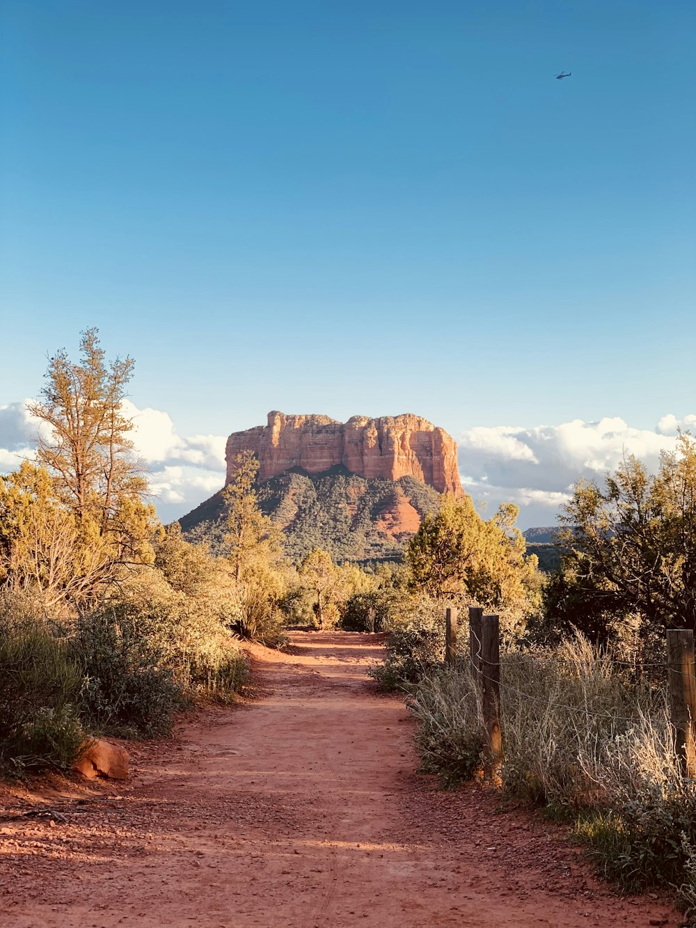 a dirt road with a mountain in the background