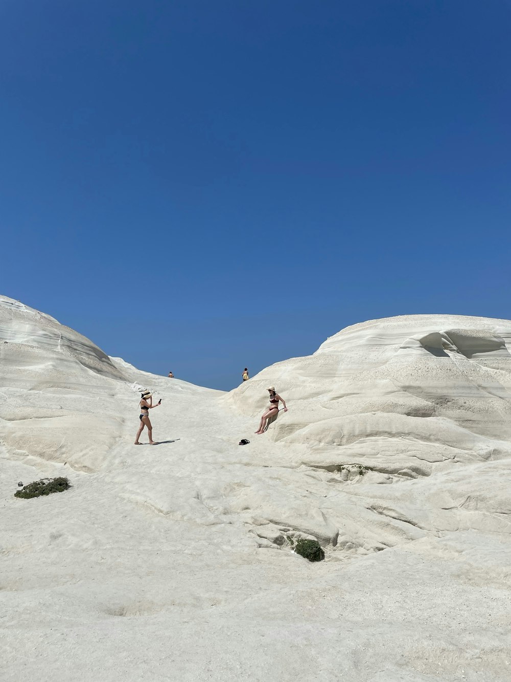 a couple of people that are standing in the sand