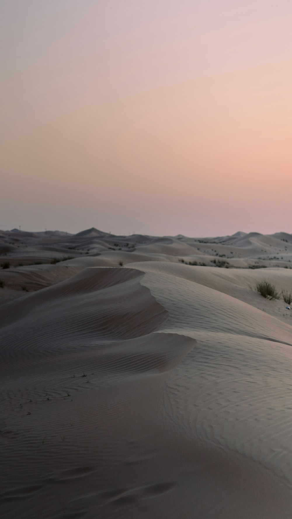 the sun is setting over the sand dunes