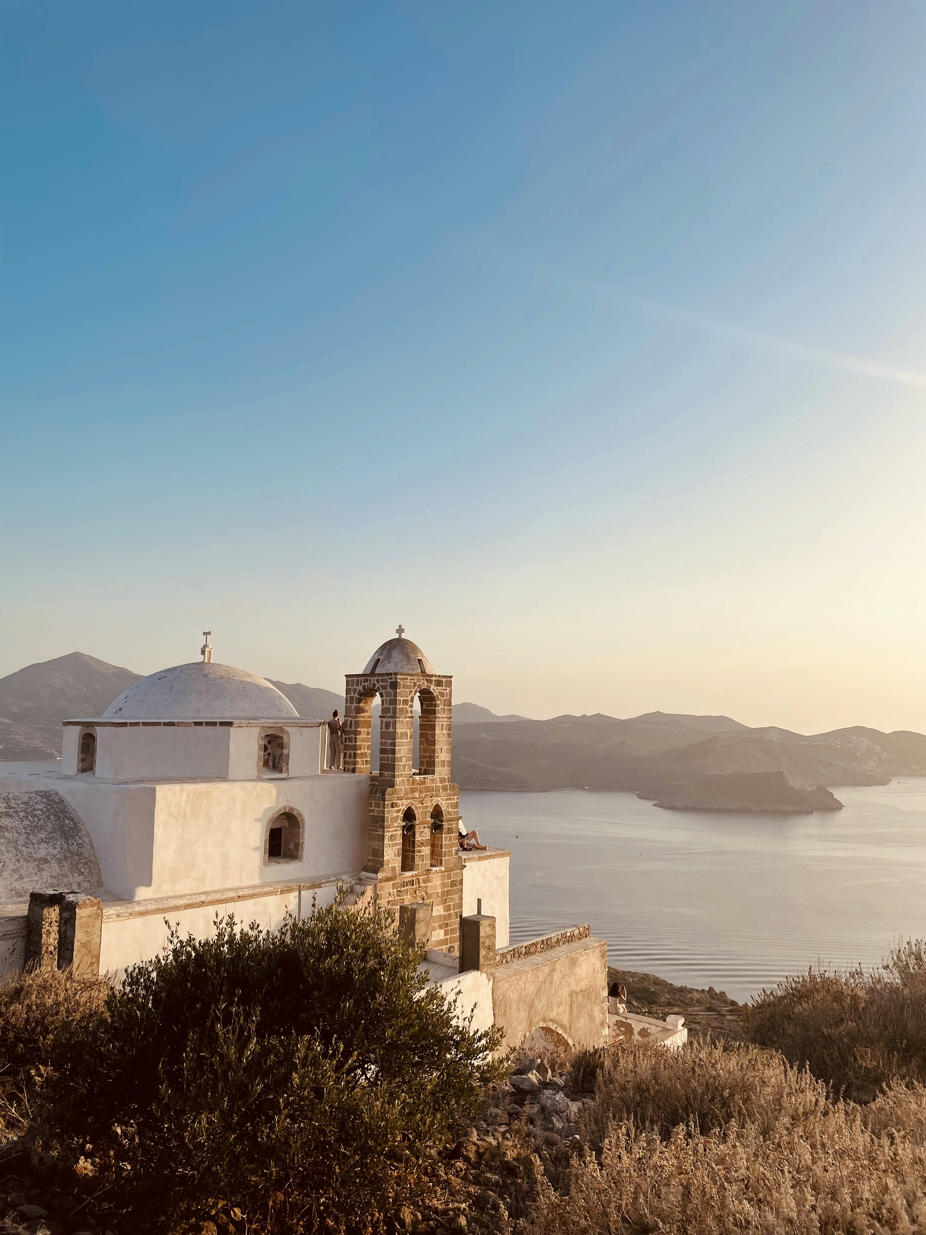 a white church on a hill overlooking a body of water