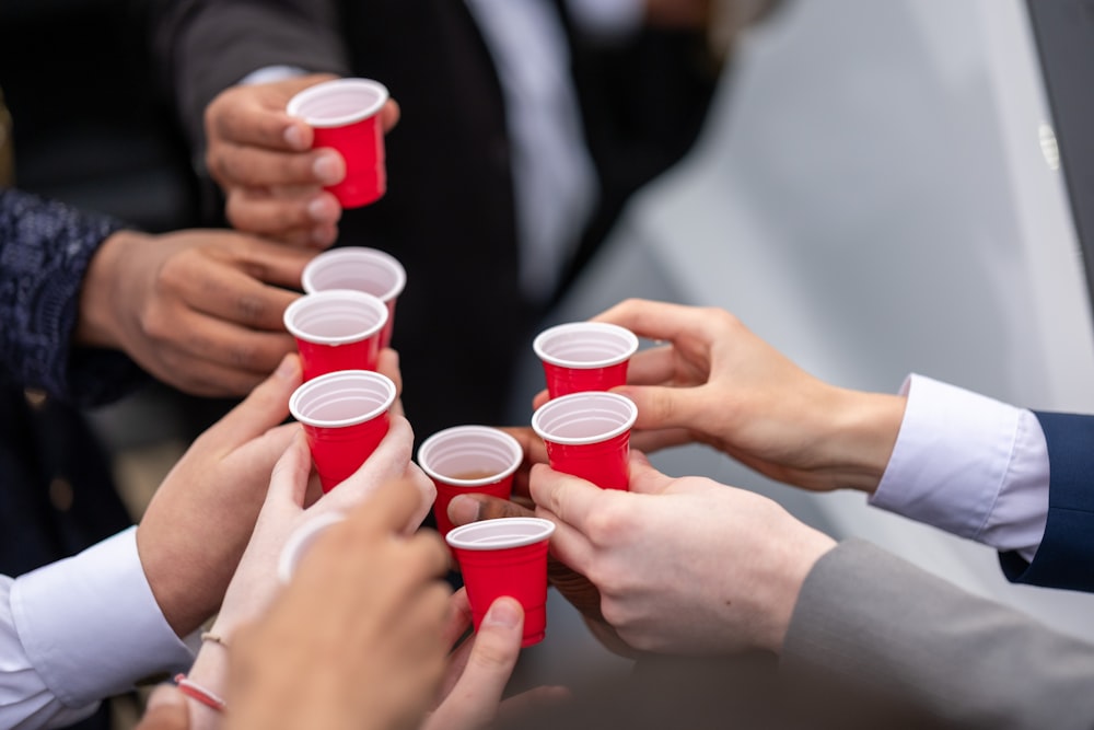a group of people holding red cups in their hands
