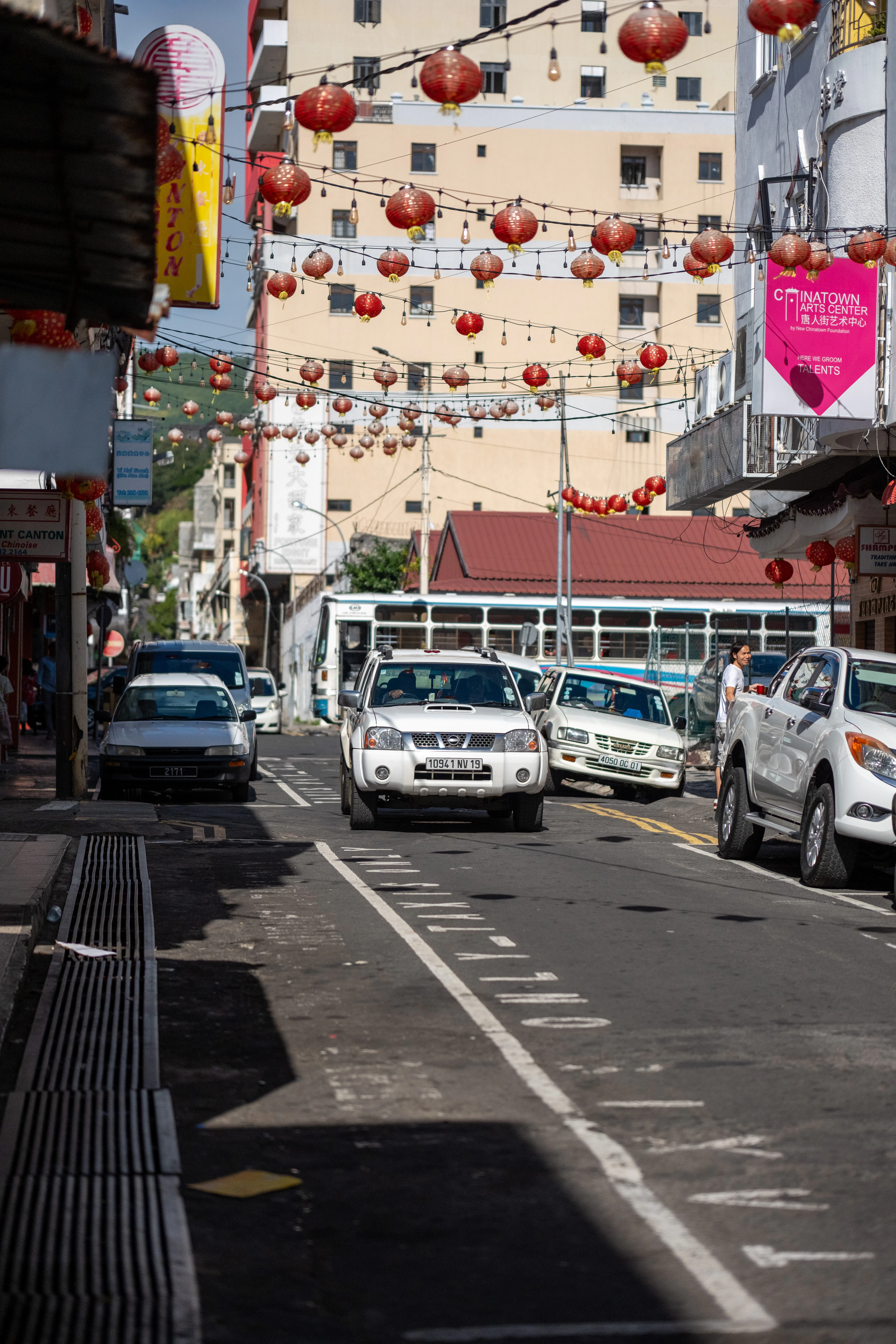 A street in the Chinatown quarter of Port Louis, Mauritius, hung with red lanterns above traffic and shopfronts