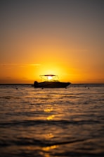 a boat is out on the water at sunset