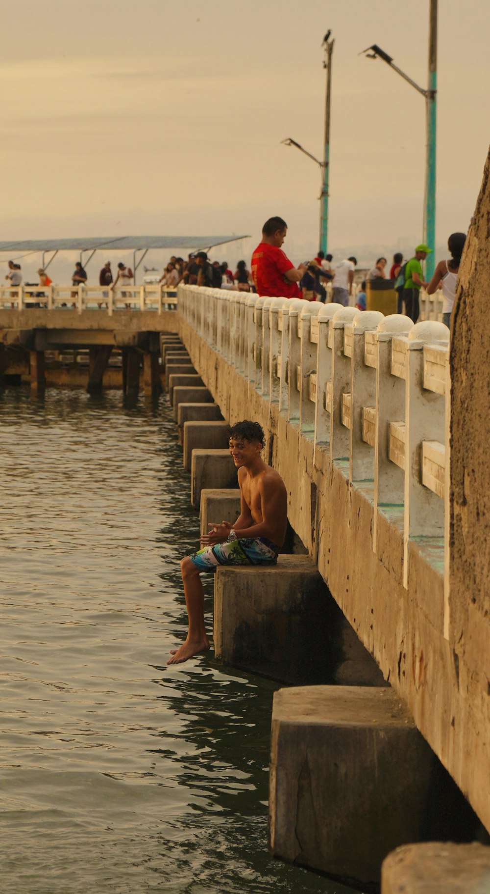 a boy is sitting on concrete blocks in the water