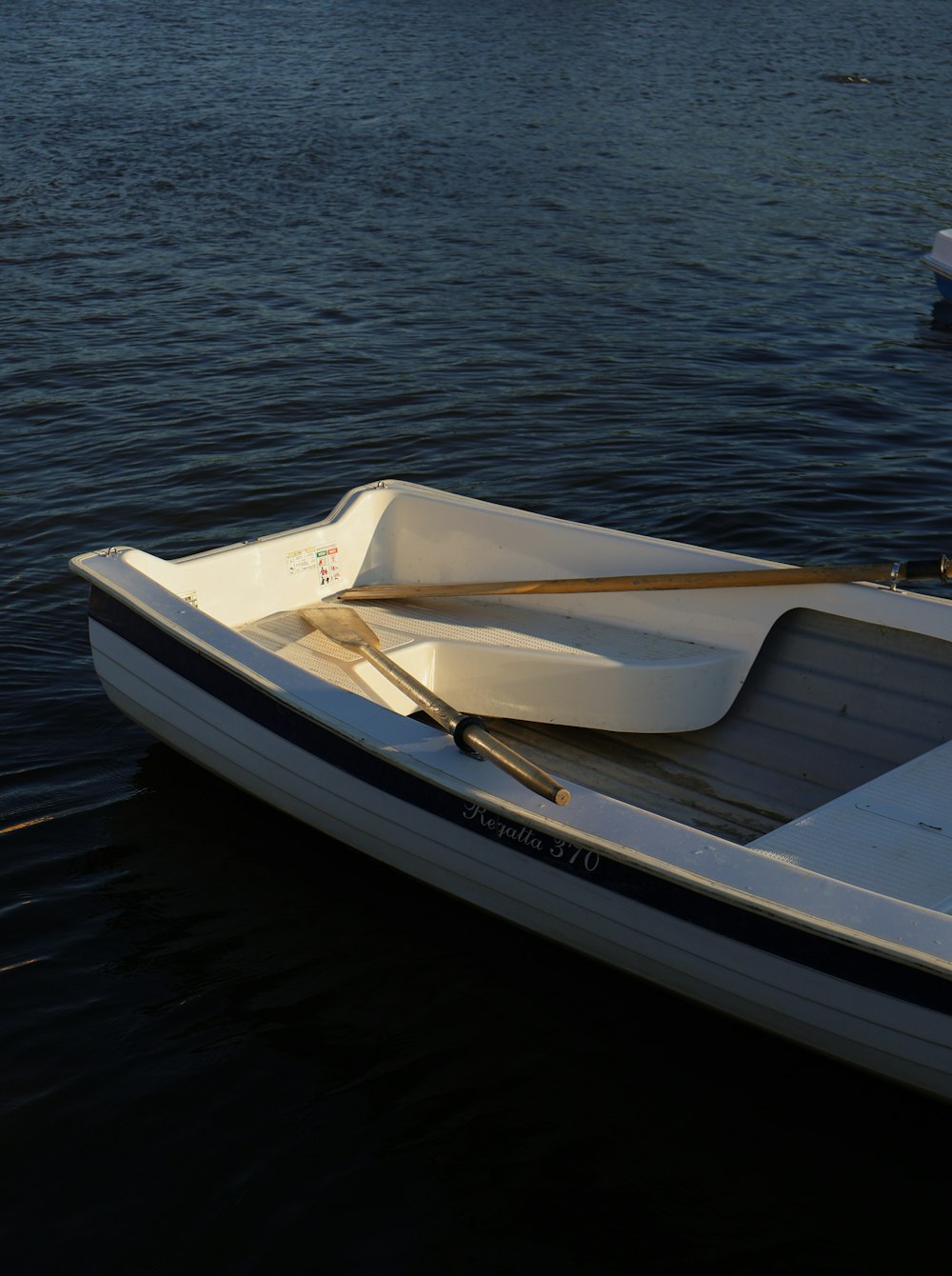 a small white boat floating on top of a body of water